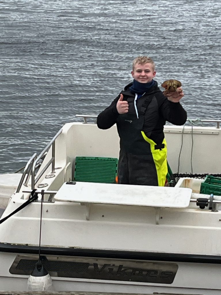 A local kid in Alesund Norway shows off the last crab available from the morning catch