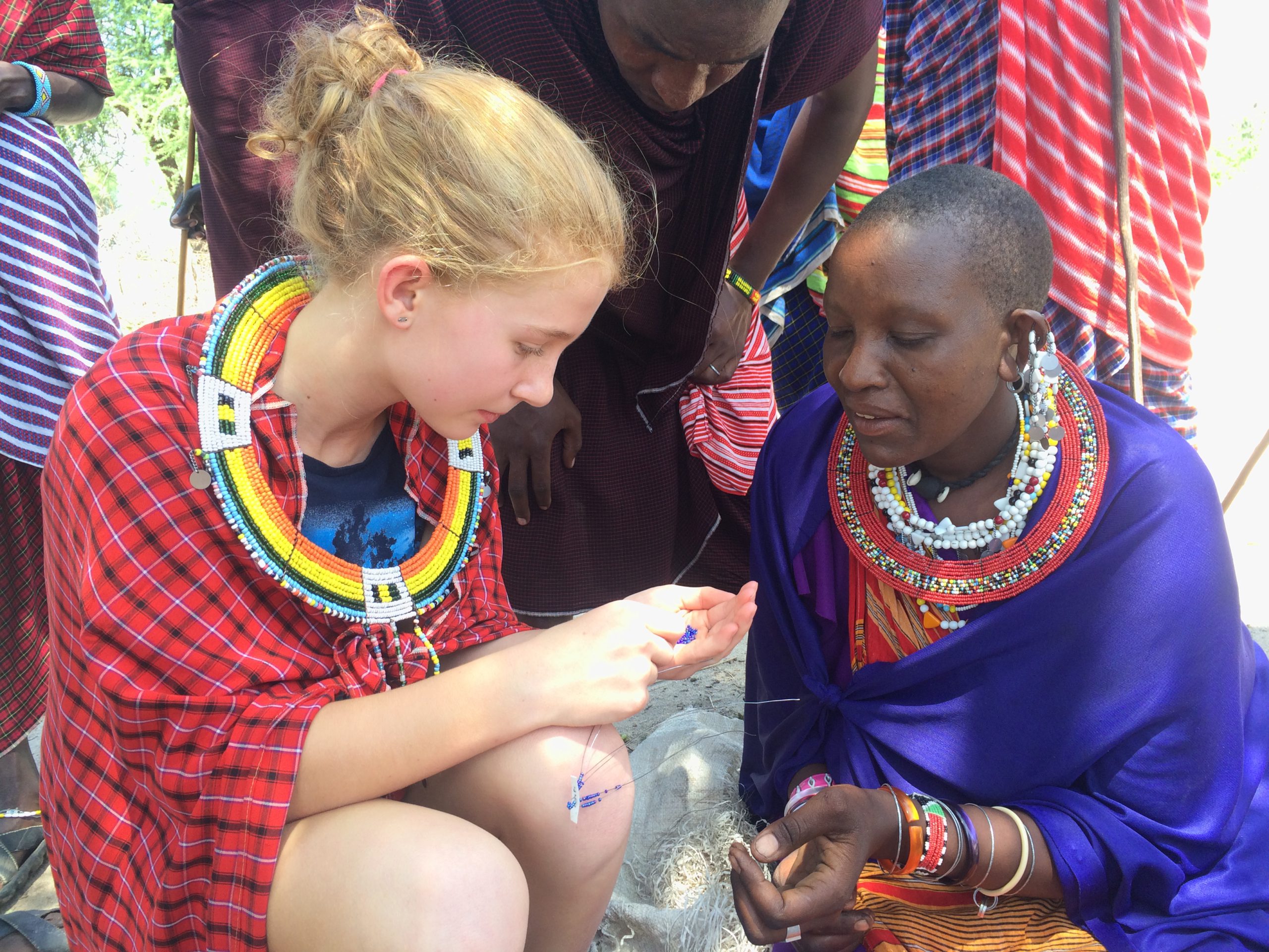 Dolan family spending time with the locals, learning how to make bracelets in Tanzania (Wildland Adventures photo)
