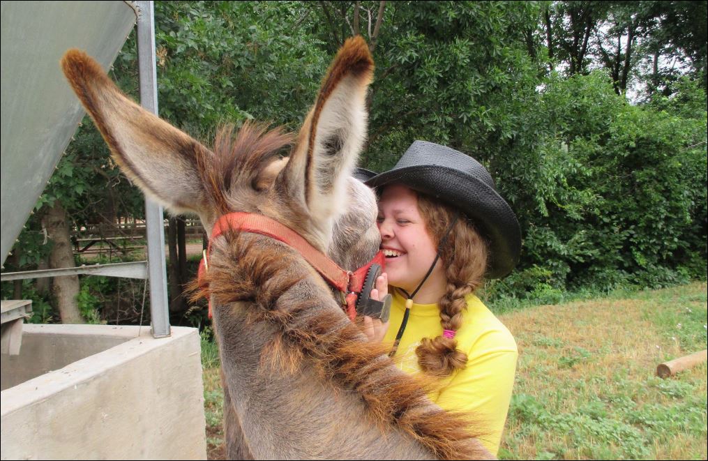 Clint the Donkey gets a hug at the Slyvan Dale Guest Ranch in Colorado