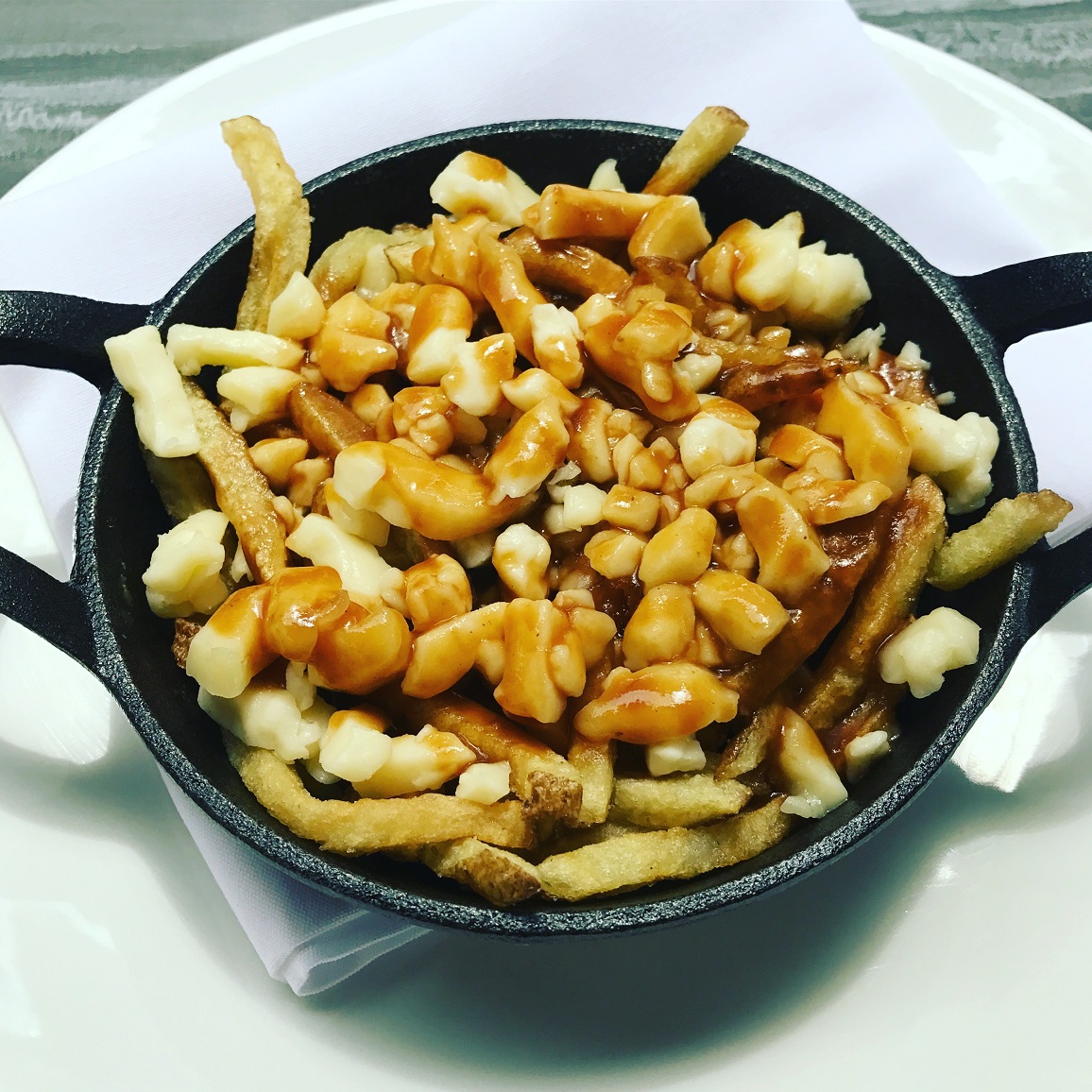 French fries and cheese curds topped with gravy, or how the locals like to call it, Poutine.