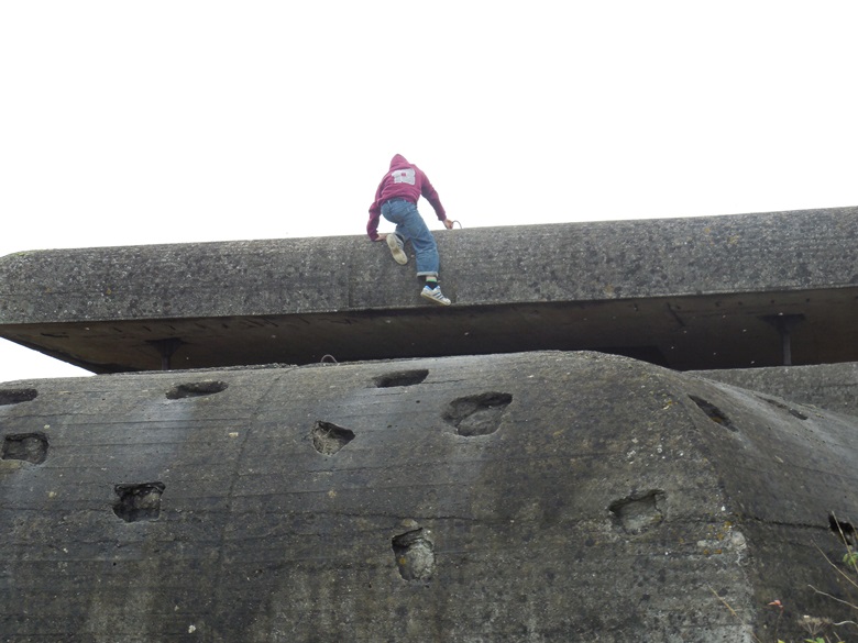 Kids climb on one of the many fortifications of the Atlantic Wall near Omaha Beach