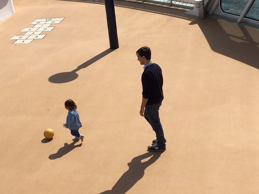 Lilly and her dad kicking ball on Queen Mary 2