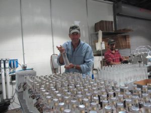 Owner Pat Scanlon handfilling vodka bottles at Woody Creek Distillers
