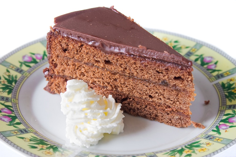 Slice of traditional Austrian Sacher Torte cake with whipped cream