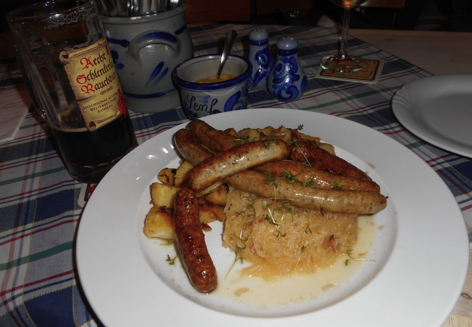 Sausages, sauerkraut and smoky dark beer at a beer garden in Bamberg