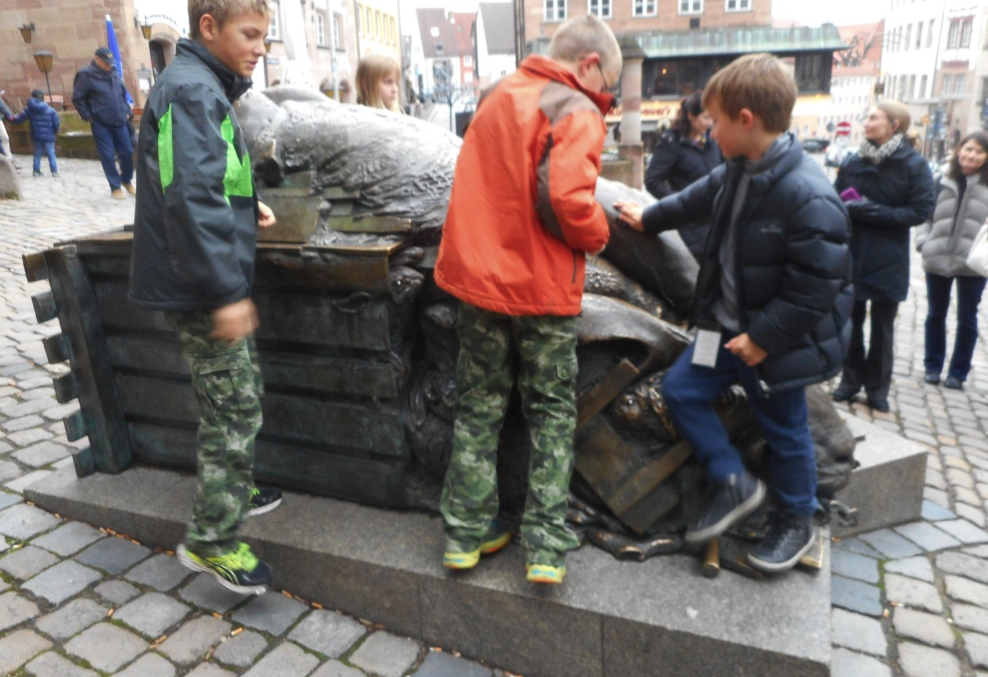 River cruise kids clambering on giant hare sculpture in Nuremberg