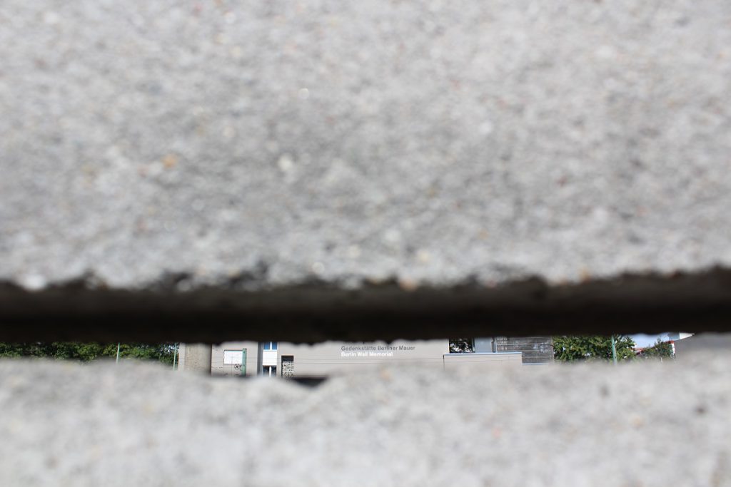 The Berlin Wall Memorial Museum seen through a slit from the old East German side of the Wall