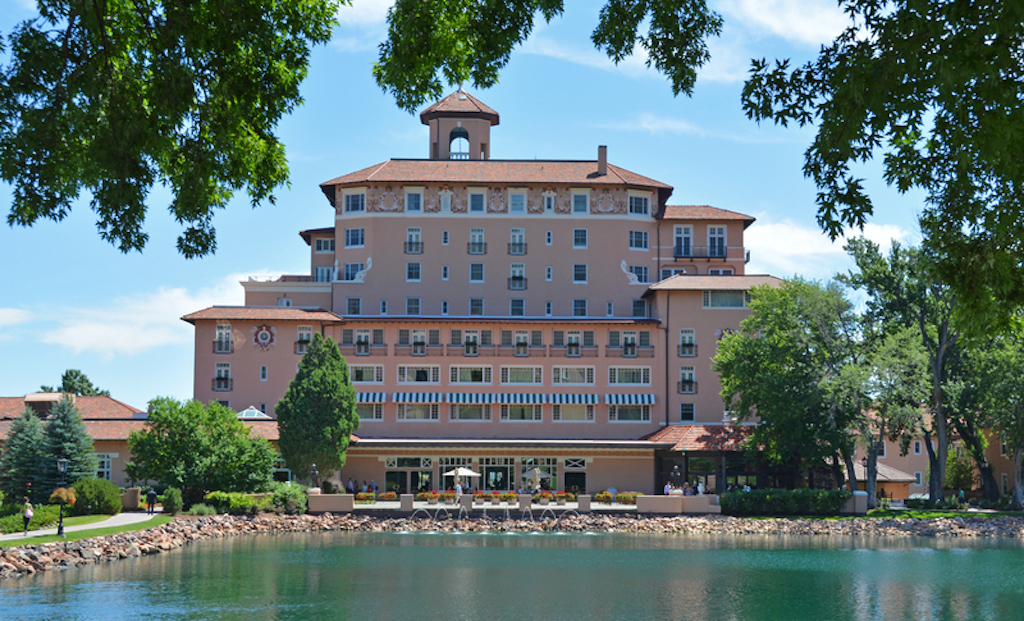 Exterior of historic Broadmoor Hotel with lake front in Colorado Springs, Colorado, USA.