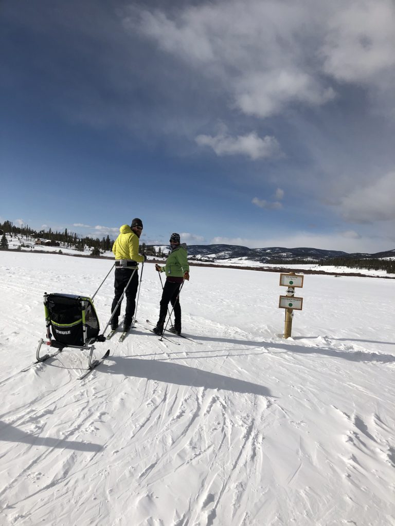 A couple on the Nordic trails at Devil's Thumb Ranch with their 7-month-old in tow