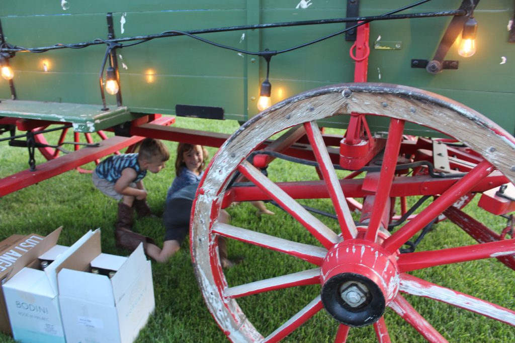 Kids playing under the wagon at the outdoor Barn Dance