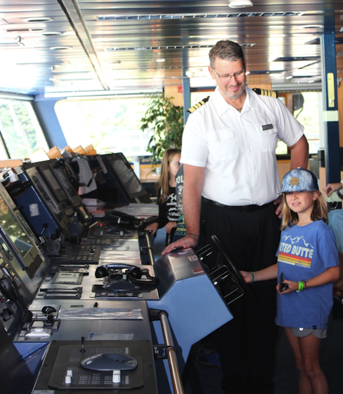 Captain Palm shows the ship's wheel to a young crew member