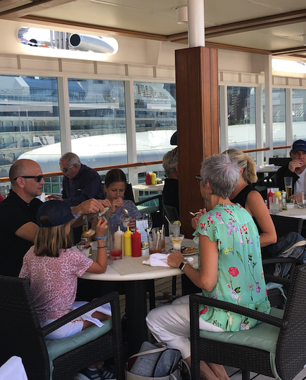 A multigen family enjoys a casual lunch on the pool deck of the Regent Seven Seas Mariner