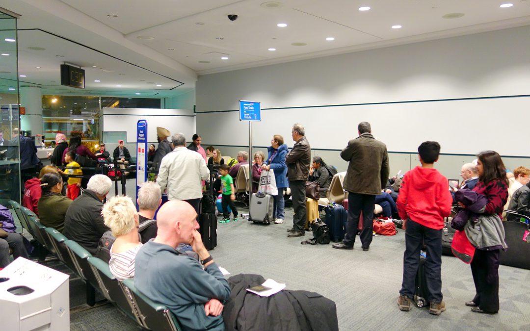 People lining up at a Toronto Pearson Airport gate.