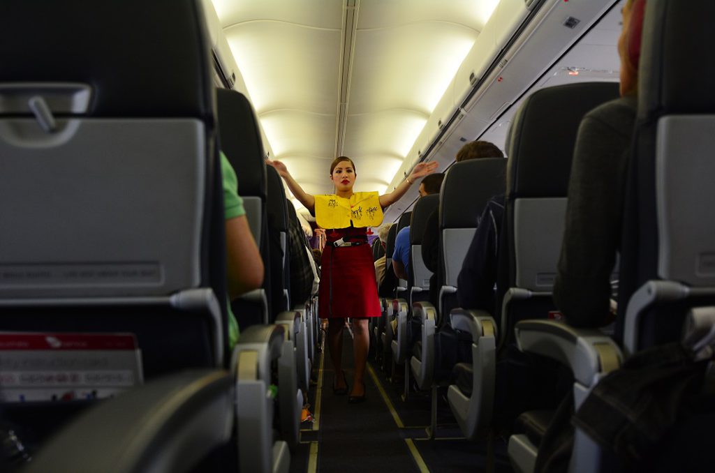 Flight Attendant giving safety briefing, which most passengers seem to ignore