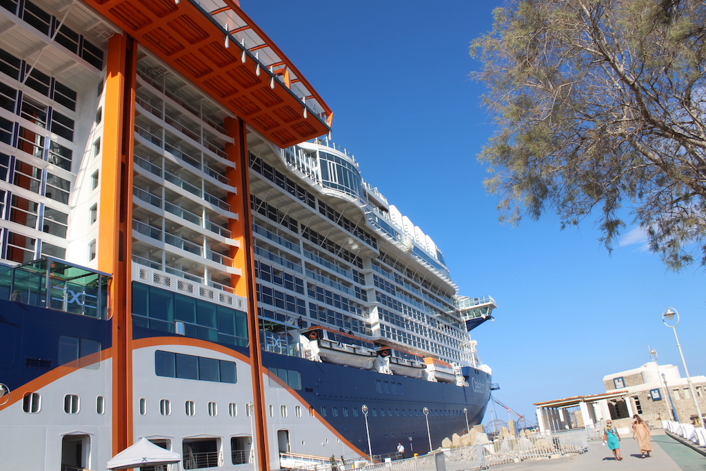 The Celebrity Apex docked in Mykonos - Orange structure is the "Magic Carpet" lounge that goes up and down the side of the new ship