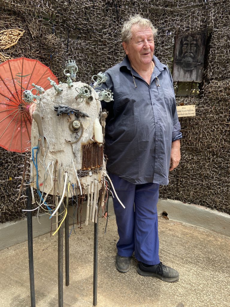 Artist Herman Van Bergen with eclectic sculpture representing the effects of Covid-19