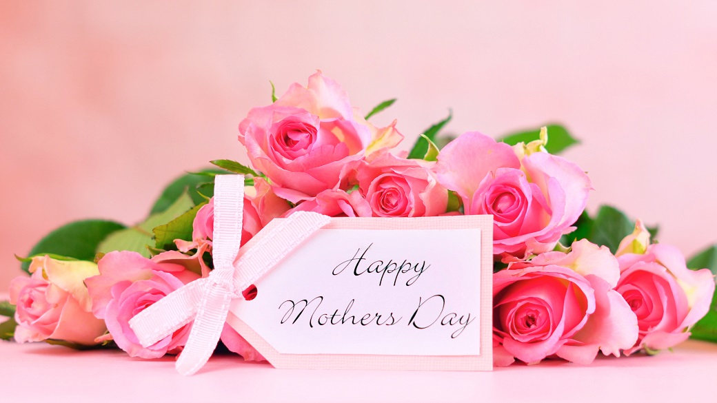Pink roses on pink wood table, Happy Mother`s Day background closeup with gift card .