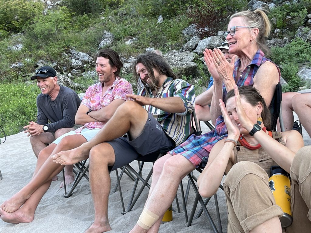 The OARS river rafting group enjoys the boatmen and boatwomen's stories after dinner on the Salmon River