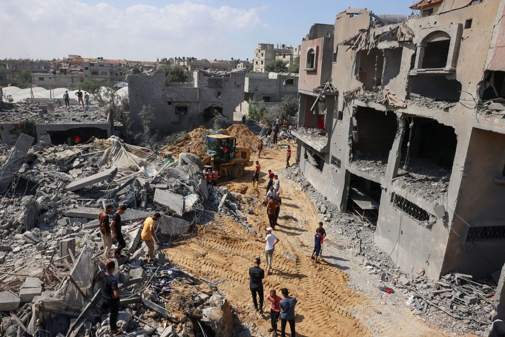 Palestinian rescuers search the rubble of destroyed buildings following an Israeli strike, as battles between Israel and Hamas militants continue for the sixth consecutive day in the city of Rafah, in the southern Gaza Strip on Oct. 12, 2023. Thousands of people, both Israeli and Palestinians have died since Oct. 7, 2023, after Palestinian Hamas militants entered Israel in a surprise attack leading Israel to declare war on Hamas in the Gaza Strip enclave on Oct. 8.