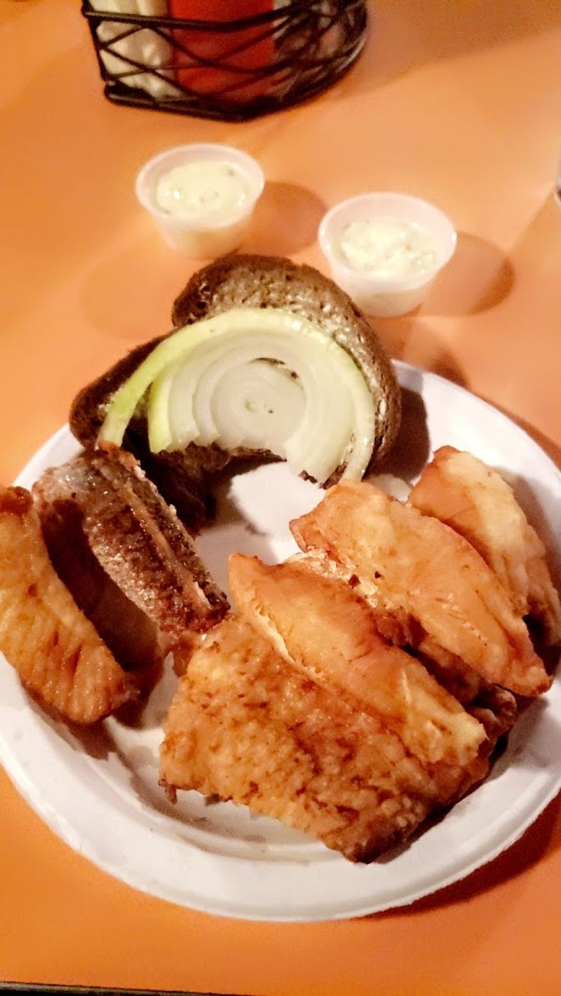 A Classic Fish Fry Served With Rye Bread And Onions