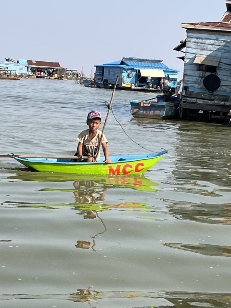 Boy on boat at floating village on Tunle Sab Lake near Siem Reap Cambodia