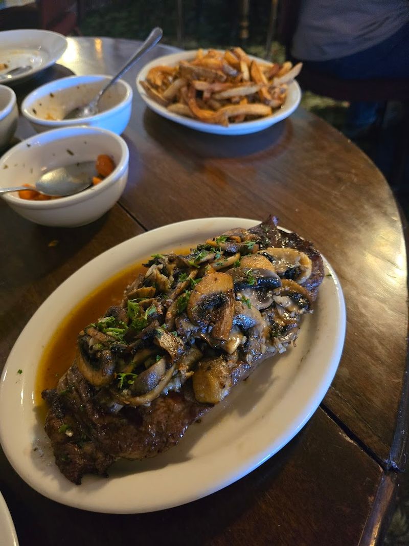 A Rib Eye Covered With Garlic, Mushrooms, Lemon, And Pepper