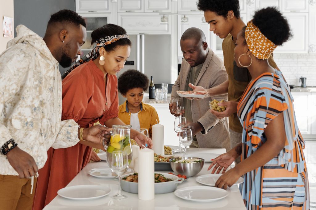 A joyful family gathering around the kitchen table for a meal, fostering togetherness and celebration. Photo by August de Richelieu