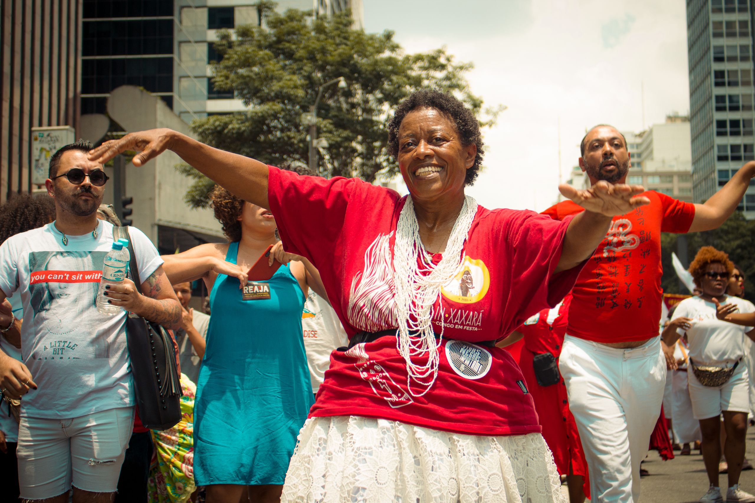 Joyful street festival with diverse group dancing and celebrating together outdoors.