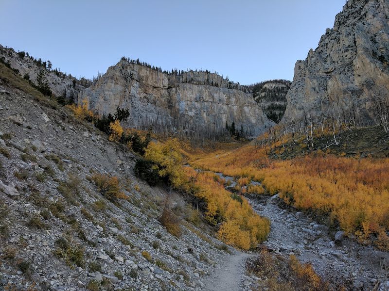 A Hidden Waterfall And Towering Cliffs