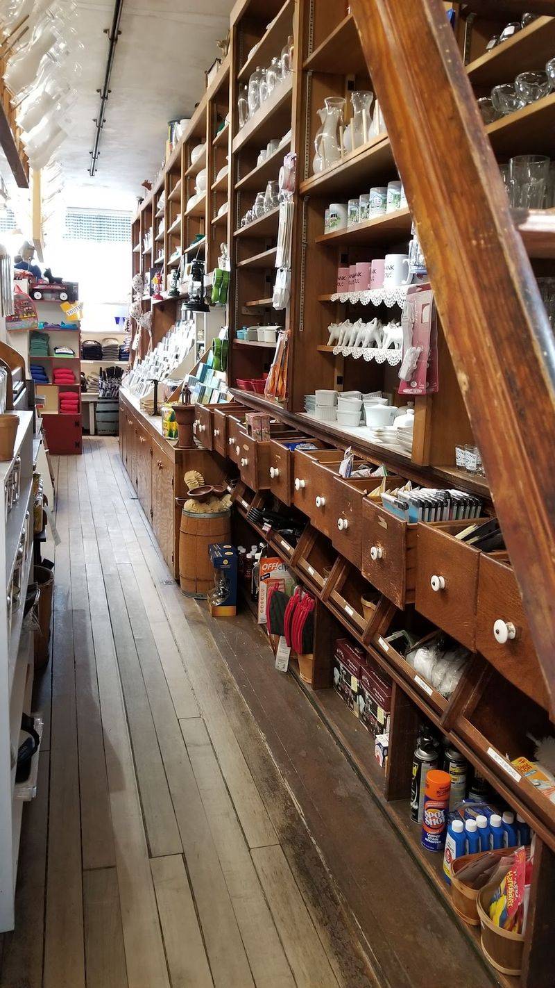 Shelves Stacked With Oil Lamps, Cookie Molds, And Cranberries