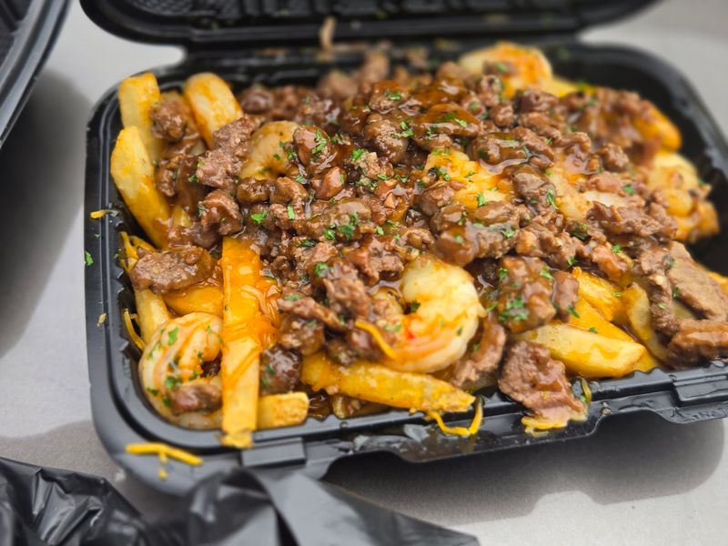 Steak And Shrimp Piled High On Golden Potatoes