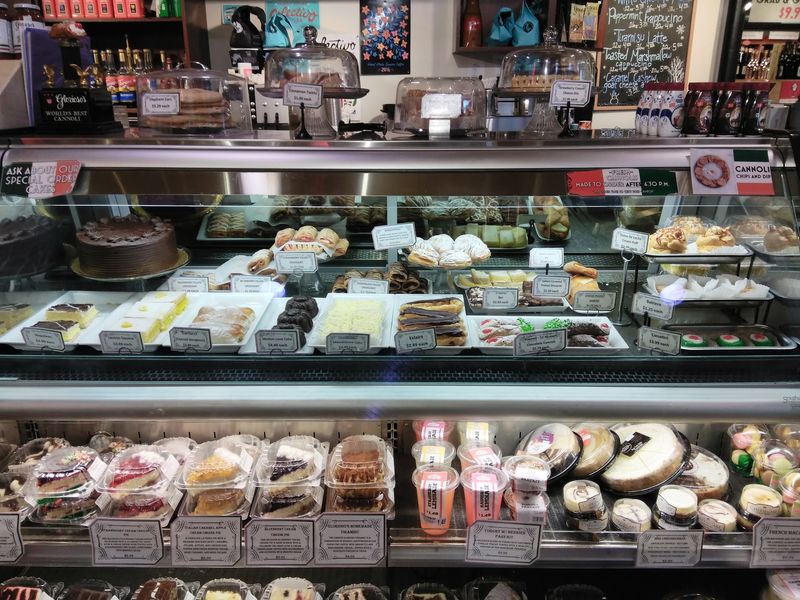 Bakery Cases Filled With Cannoli, Cookies, And Fresh Bread