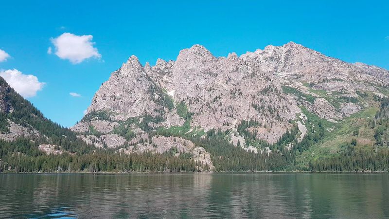 Mountain Peaks Rise Dramatically Above The Clear Water