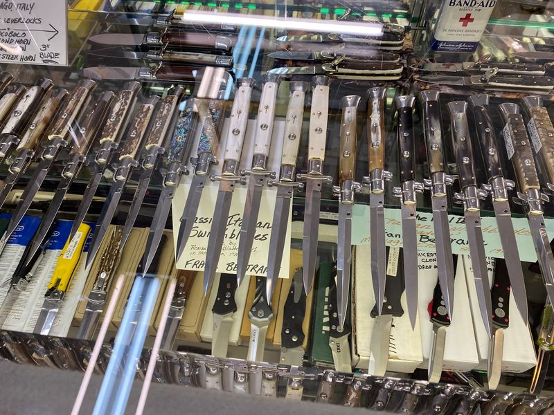 Glass Cases Full Of Knives, Watches, And Rings