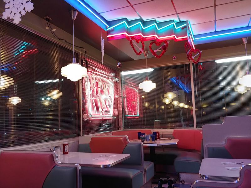 Jukeboxes At The Booths And Neon Overhead