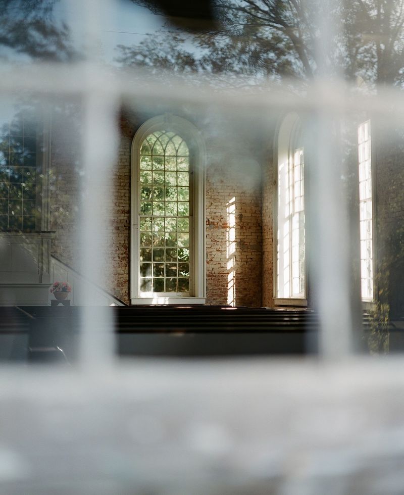 Old Pews Seen Through Window Glass