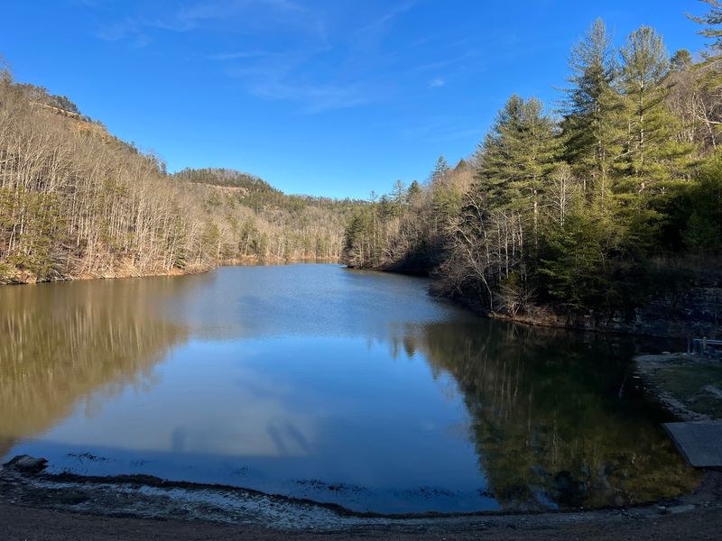 Paddle Across A Calm Lake Ringed By Cliffs