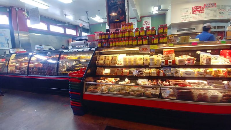 Deli Cases Packed With Imported Cheese And Cured Meats