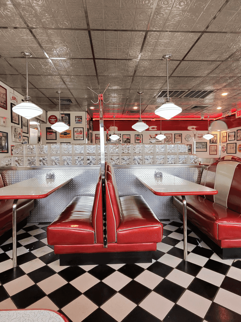 Red Booths And Checkered Floors Make Every Seat Feel Like 1955